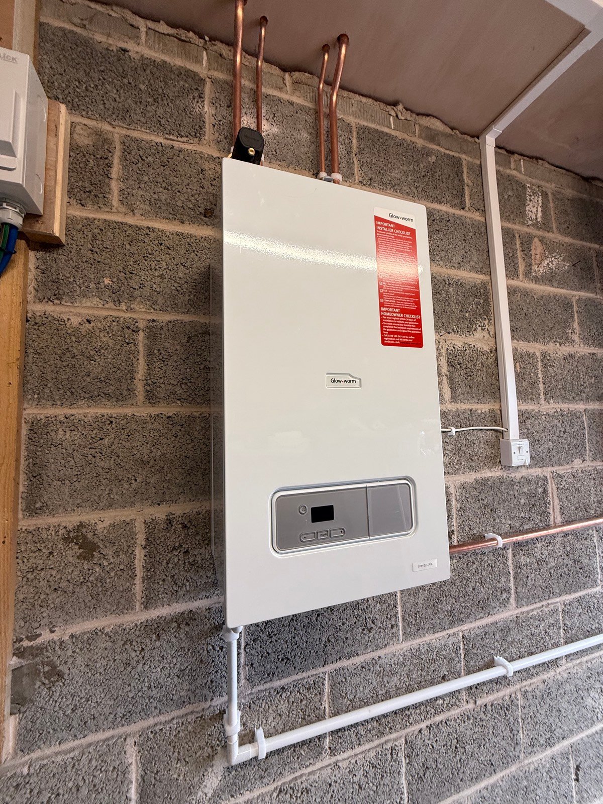 Combi boiler installed on a breeze block wall with new pipework
