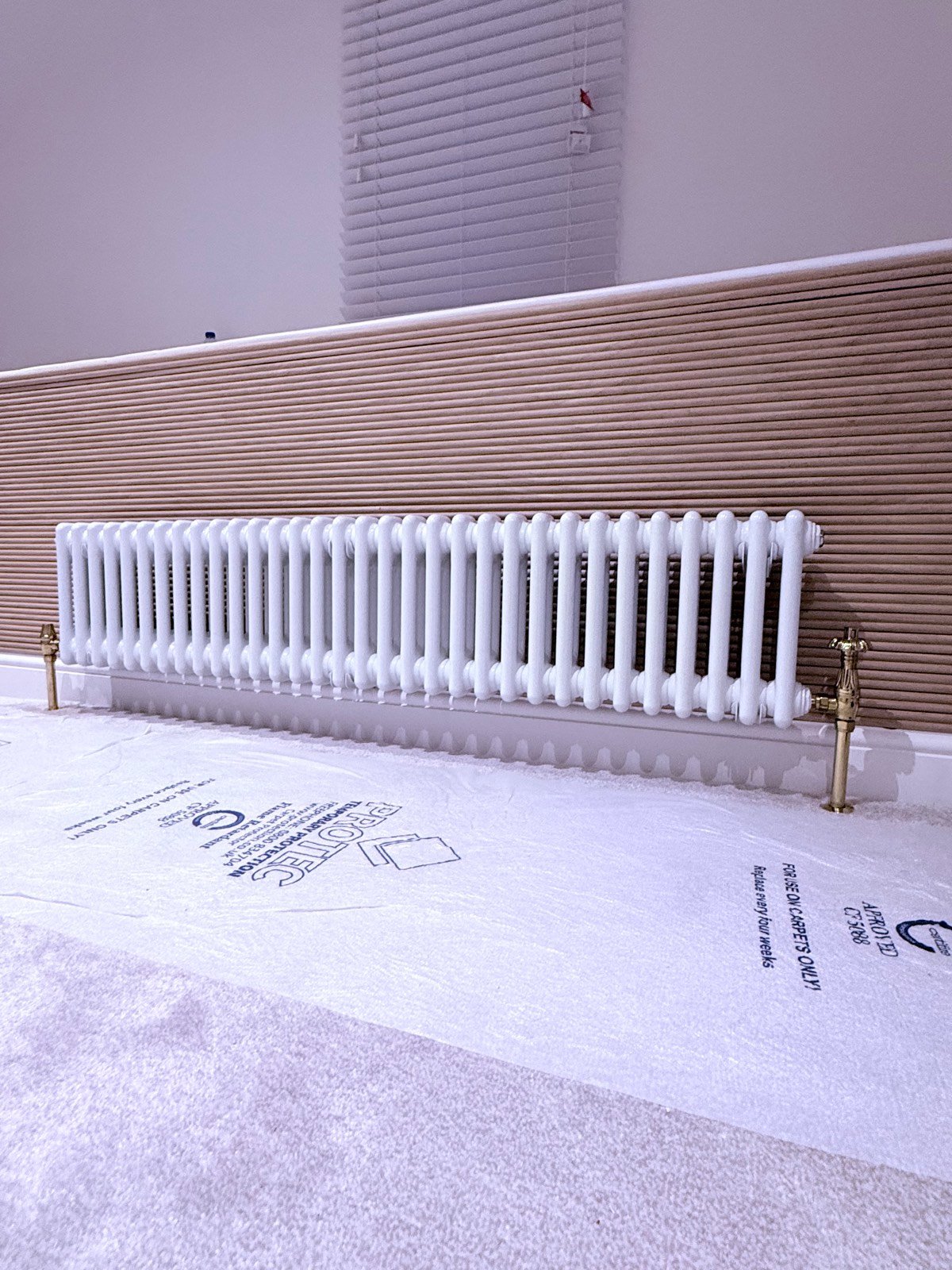 White column radiator with brass valves, freshly installed